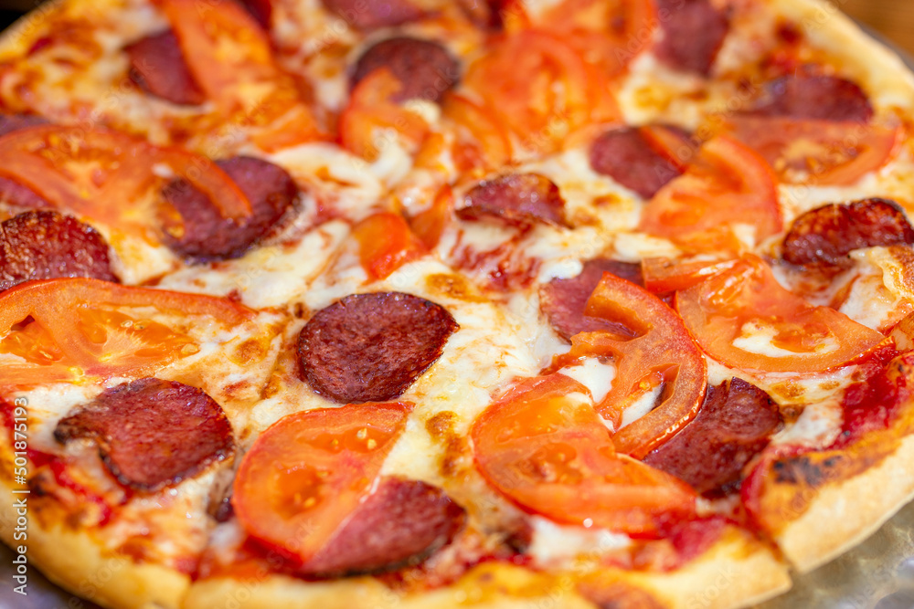 appetizing pizza with sausage and tomatoes, close-up appetizing pizza with sausage and tomatoes, close-up