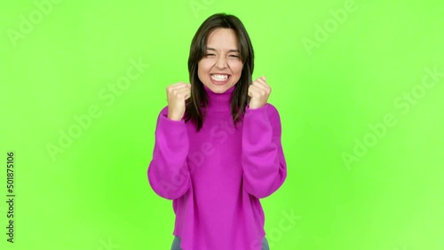 Young brunette woman celebrating a victory and surprised to be successful over isolated background. Green screen chroma key