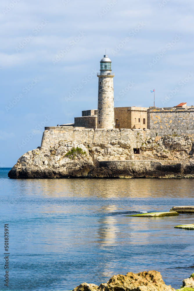 Old Havana, Cuba. February 2018 - The fortress and the lighthouse of El Morro at the entrance of Havana bay, seen from the Malecon, reflection on the sea.
