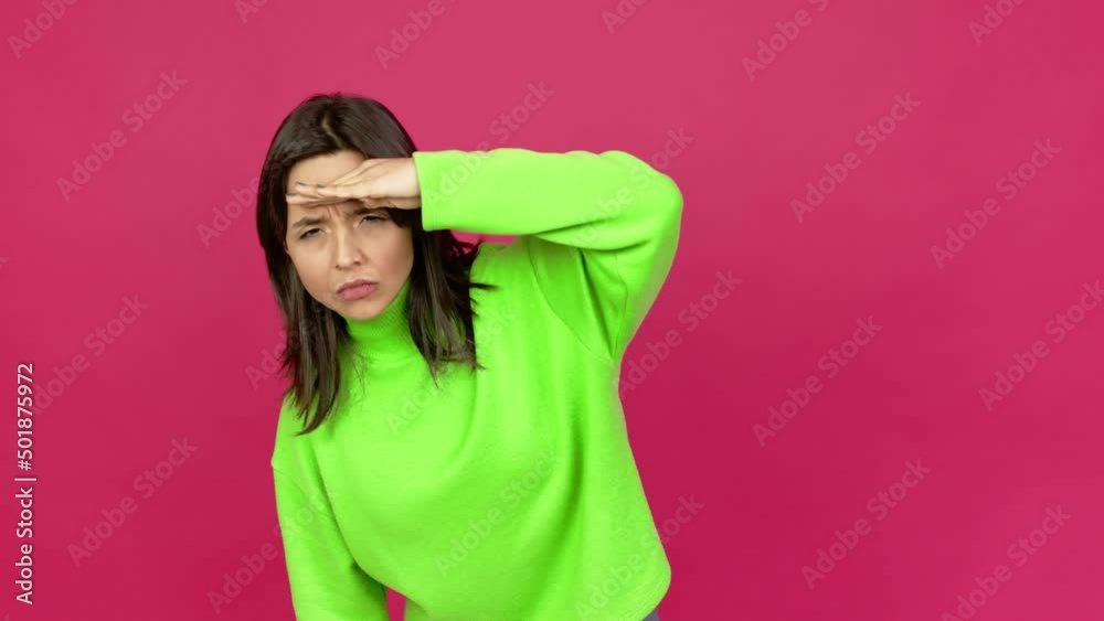 Young brunette woman looking far away with hand to look something over isolated background Young brunette woman looking far away with hand to look something over isolated background