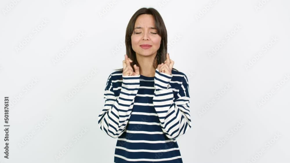 Young brunette woman with fingers crossing and wishing the best. Making a wish over isolated background Young brunette woman with fingers crossing and wishing the best. Making a wish over isolated background