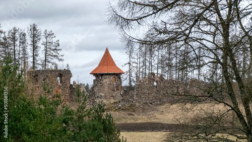 spring landscape with a view of the castle ruins, the new bright orange roof of the castle tower stands out, Ergeme castle ruins, Valka district, Latvia photo