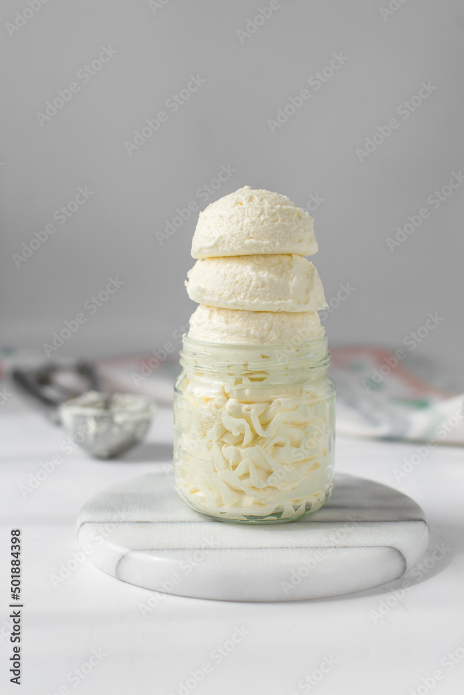 Scoop of american buttercream in a glass jar, scoops of buttercream with air pockets, textured buttercream in a glass jar, scoops of ice cream in glass cup Scoop of american buttercream in a glass jar, scoops of buttercream with air pockets, textured buttercream in a glass jar, scoops of ice cream in glass cup