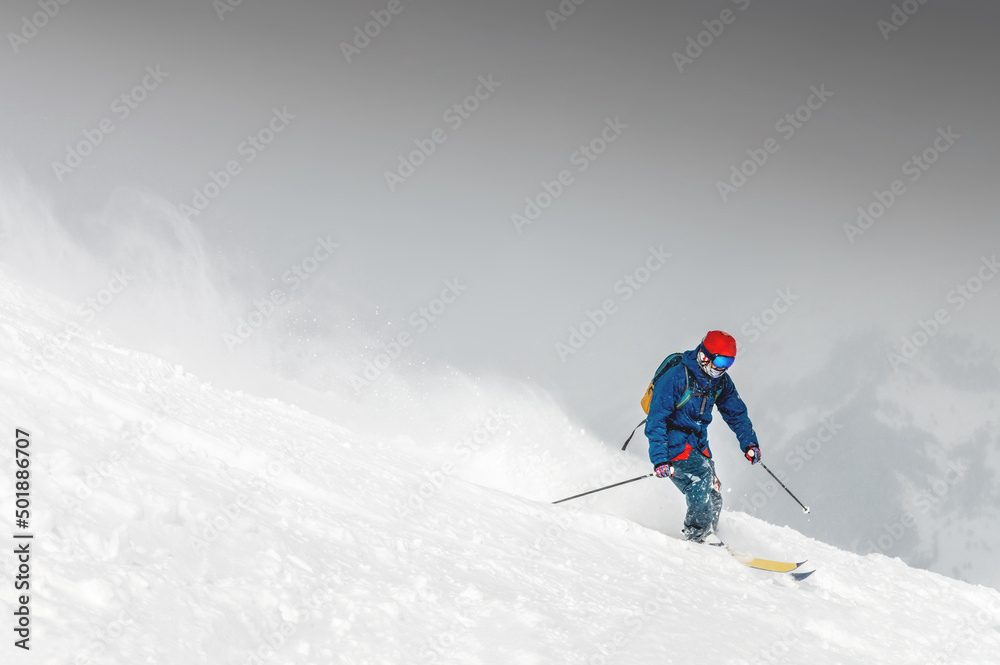 Skiing, skier, frisky - freeride, a man is stylishly skiing on a snowy slope with snow dust plume behind him
