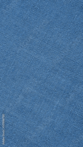 Blue woven surface close-up. Linen textile texture. Graceful color fabric background. Vertical textured braided backdrop. Textured mobile phone wallpaper. Macro