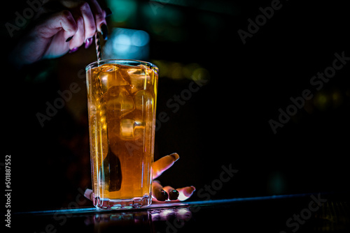 woman bartender hand at the bar or pub to prepare cocktail Long Island in glass