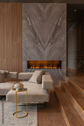 living room, marble wall fireplace and stylish bookcase in chic expensive interior of luxury country house with a modern design with wood and led light, gray furniture with gold elements