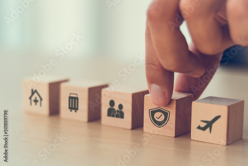 Travel safety and travel insurance concept. Wooden cubes with protect safety travel icon. Intended to cover medical expenses, trip cancellation, lost luggage and other losses incurred while traveling. photo