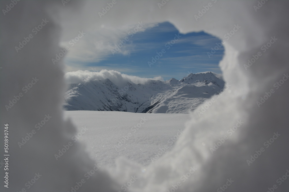 through the peephole out of snow you can see mountains in the region of Sedrun in the swiss alps in the autumn with the first snow. through the peephole out of snow you can see mountains in the region of Sedrun in the swiss alps in the autumn with the first snow.