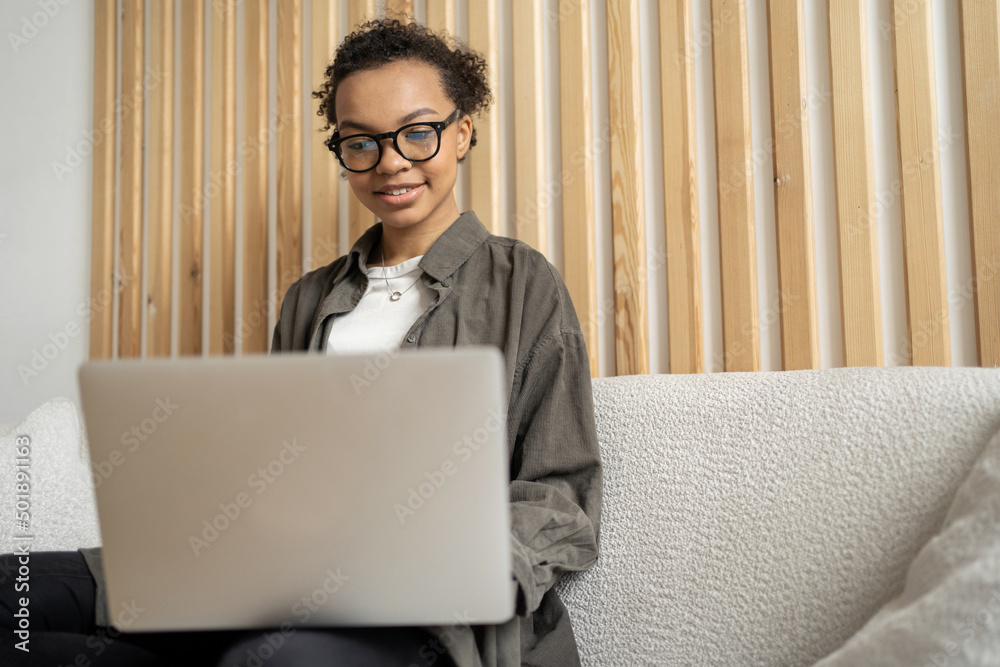 A woman with glasses workplace uses a laptop computer report to the company in the office. Designer communication video communication with the client.