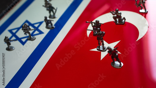 The concept of the economic and political crisis between Israel and Turkey, toy soldiers attacking each other against the background of national flags.