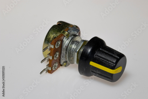 Potentiometer with knob on white background. Variable resistance. Electronic components. photo