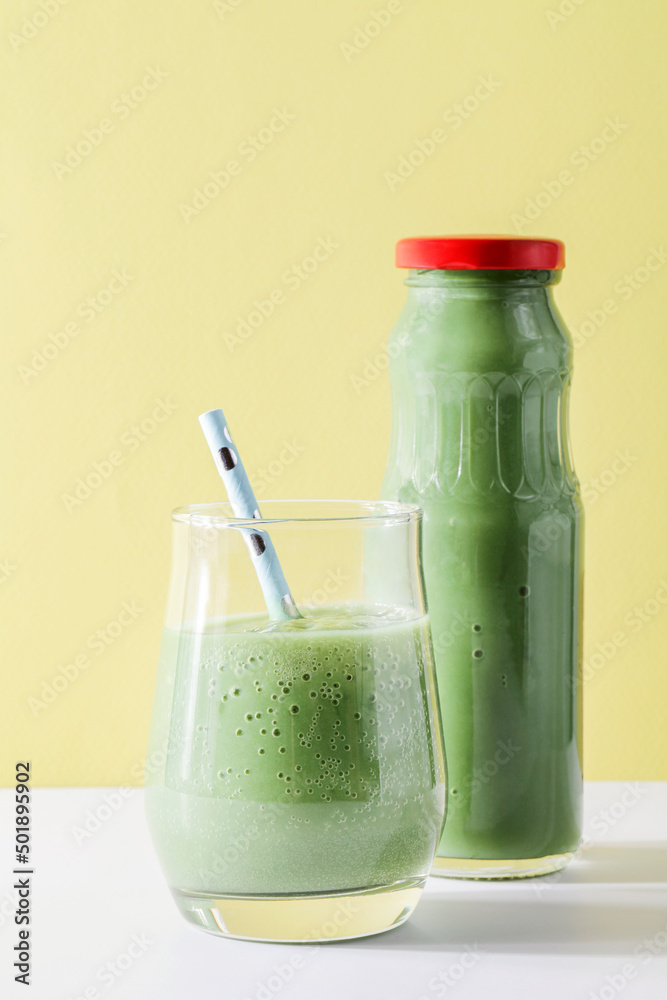 healthy green smoothie in glass, bottle with straw on yellow background. Vegetarian healthy lifestyle concept.refreshing drink. quick snack.copy space healthy green smoothie in glass, bottle with straw on yellow background. Vegetarian healthy lifestyle concept.refreshing drink. quick snack.copy space