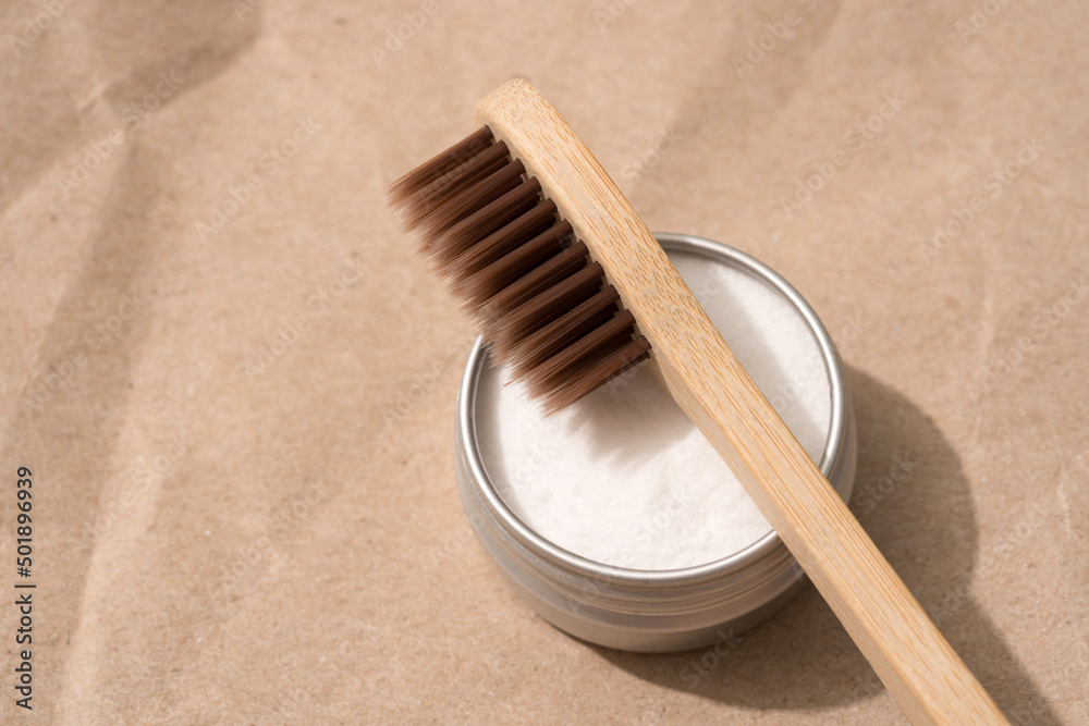 Brown wooden bamboo toothbrushes with mineral toothpowder kaolin in metal container on kraft paper background. Natural bath products, organic dentifrice. Top view Brown wooden bamboo toothbrushes with mineral toothpowder kaolin in metal container on kraft paper background. Natural bath products, organic dentifrice. Top view