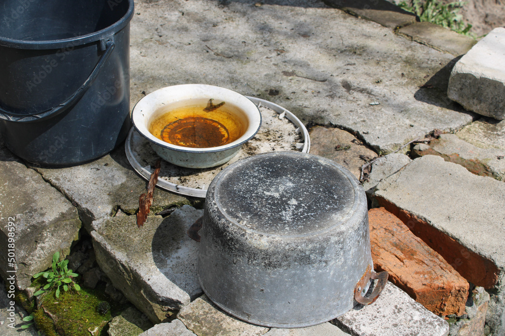 Old dishes, on a broken brick threshold Old dishes, on a broken brick threshold