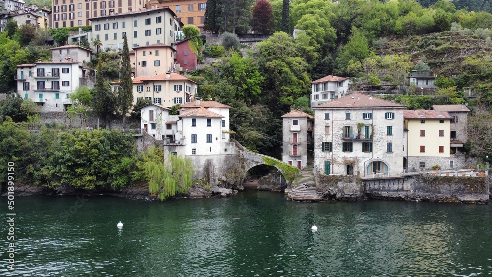 Beautiful view from the lake to the shore with villas. Old town with a bridge