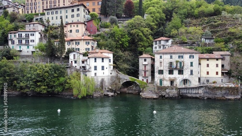 Beautiful view from the lake to the shore with villas. Old town with a bridge