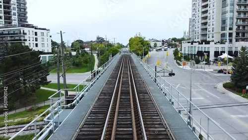Wallpaper Mural Drone Flying Low Over Commuter Railroad Train Tracks Infrastructure into City Downtown Core between two Condominium Apartment Buildings in Guelph, Ontario, Canada Torontodigital.ca