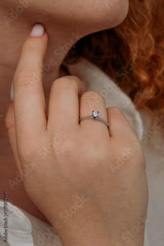 Close-up of elegant diamond ring on female finger. Love and wedding concept.Soft and selective focus.