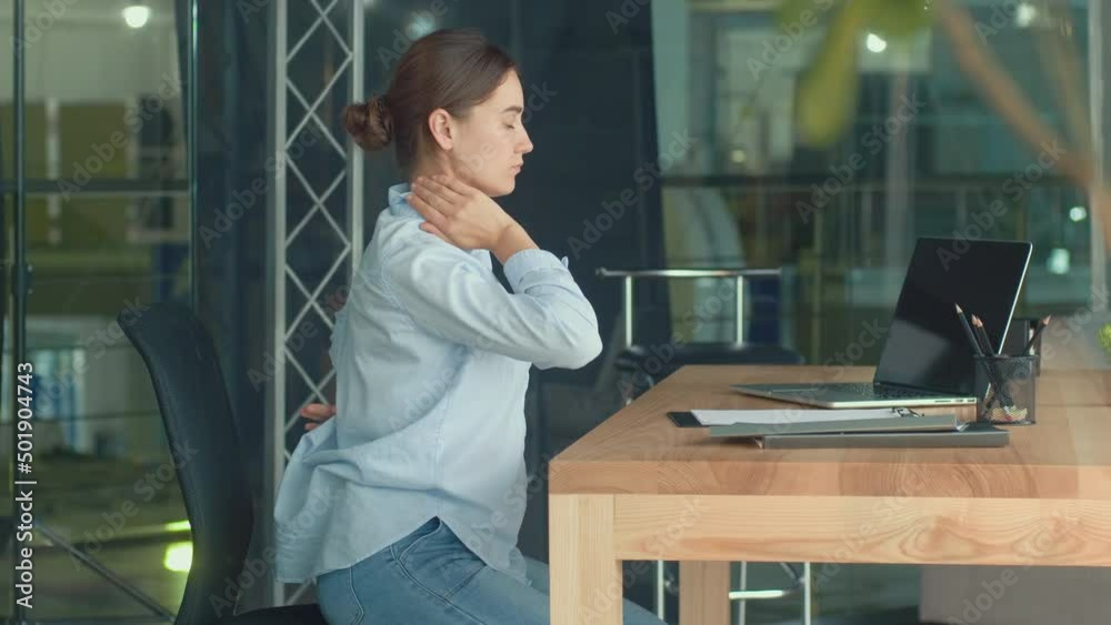 Focused Woman Work at a Table With a Laptop Suddenly Feeling Pain in Neck and Back. Woman Feeling Tired of Long Sedentary Lifestyle Tries to Relax and Relieve Pain by Rubbing Massaging Neck Focused Woman Work at a Table With a Laptop Suddenly Feeling Pain in Neck and Back. Woman Feeling Tired of Long Sedentary Lifestyle Tries to Relax and Relieve Pain by Rubbing Massaging Neck