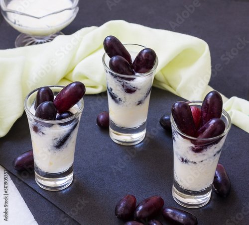 Lassi is an Indian smoothie made from frozen yogurt and topped with fresh red grapes. It is sweet and mostly consumed in summer as alternate to juices. Close-up and front view.