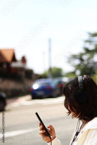 Young girl looking at the mobile on the street