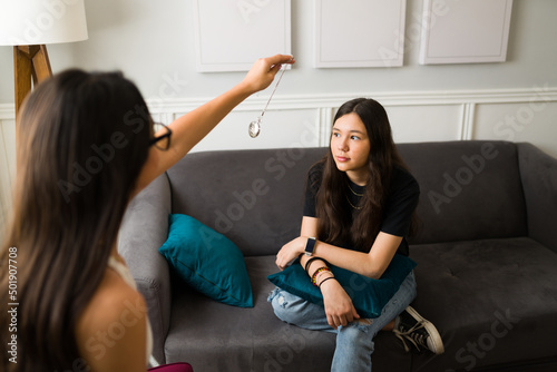 Therapist using a clock to hypnotize a teen patient