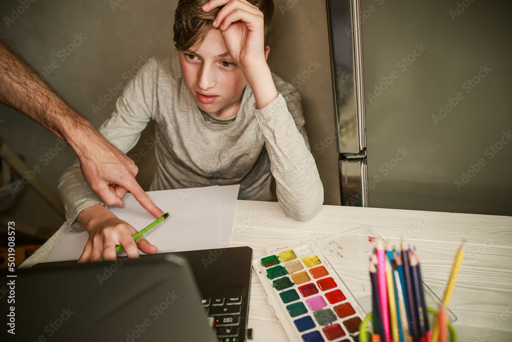 A teenager looks at a laptop screen. Remote learning. Back to school. Classes for children online during the war in Ukraine A teenager looks at a laptop screen. Remote learning. Back to school. Classes for children online during the war in Ukraine