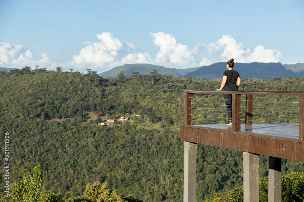 Young woman looking at mountains in a lookout viewpoint, Rio Grande do Sul highlands, Brazil - obrazy, fototapety, plakaty 