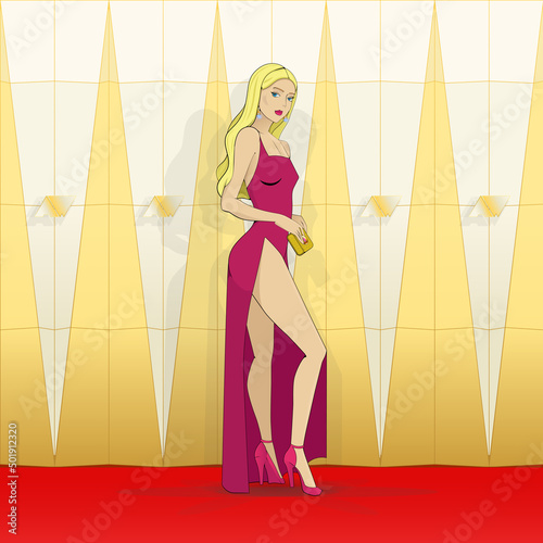 Red carpet, awards ceremony. A young woman in an evening dress poses in front of a geometric installation. photo