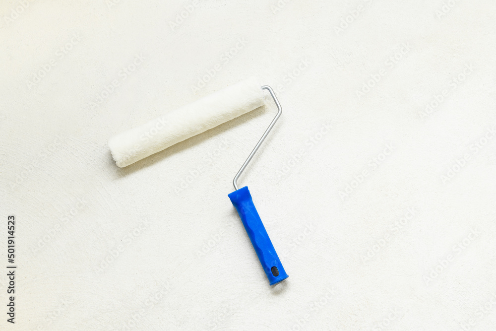 Paint roller on the concrete floor, copy space. Repair tools lies on floor Paint roller on the concrete floor, copy space. Repair tools lies on floor