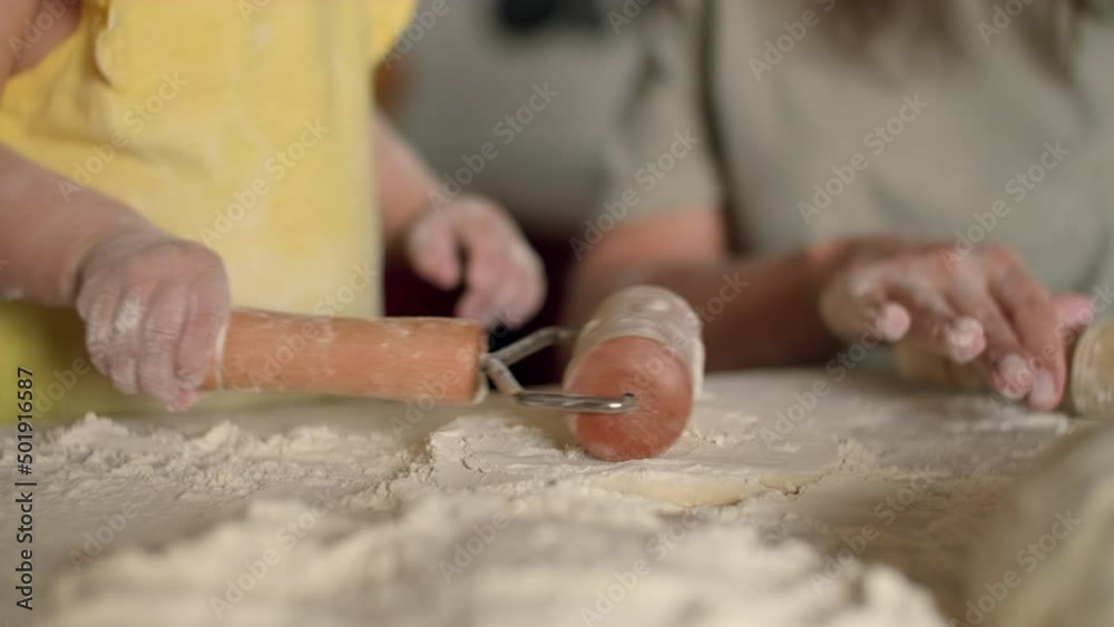 The child rolls out the dough on the table using a roller.Dough Cooking,Child Education,Home Food,Sweet Pastries. The child rolls out the dough on the table using a roller.Dough Cooking,Child Education,Home Food,Sweet Pastries.