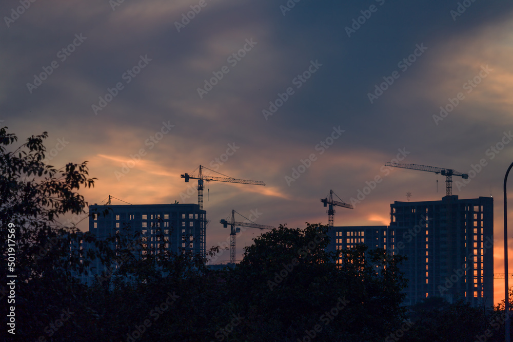 High multi storey residential apartment buildings under construction. Concrete and brick framing of high rise housing. Real estate development in urban area. High multi storey residential apartment buildings under construction. Concrete and brick framing of high rise housing. Real estate development in urban area.