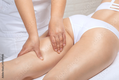 Masseur makes anti-cellulite massageon the legs  thighs  hips and buttocks in the spa. Overweight treatment  body sculpting.Cosmetology and massage concept.