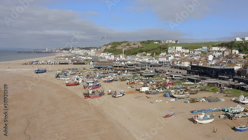 Aerial footage of Hastings Stade Beach towards the largest land based fishing fleet in Europe with local boats and equipment in view. photo