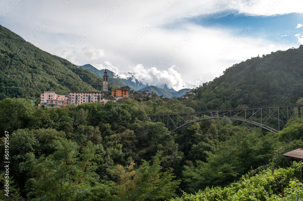 A small village in the Swiss mountains with an iron railway bridge over the valley. A small village in the Swiss mountains with an iron railway bridge over the valley.