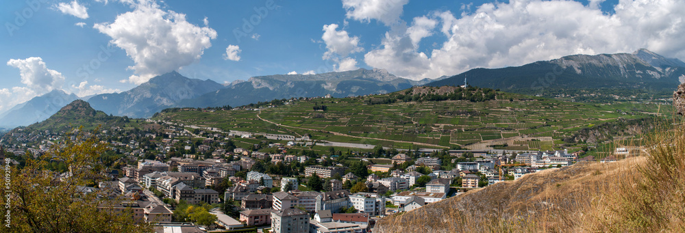 Panorama of the Alpine mountain range with the city of Sion in the valley