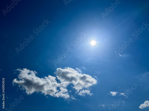 Blue sky with clouds. Bright sun in a blue sky. Sky with copyspace