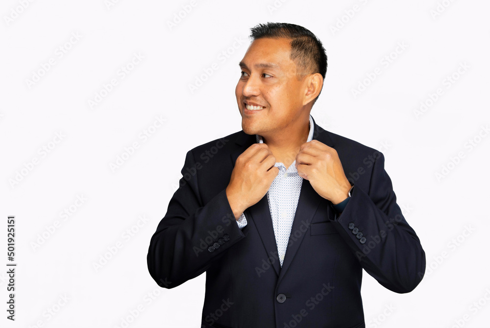 Hispanic man in business suit smiling while adjusting his collar and not looking at the camera shot on a white background Hispanic man in business suit smiling while adjusting his collar and not looking at the camera shot on a white background