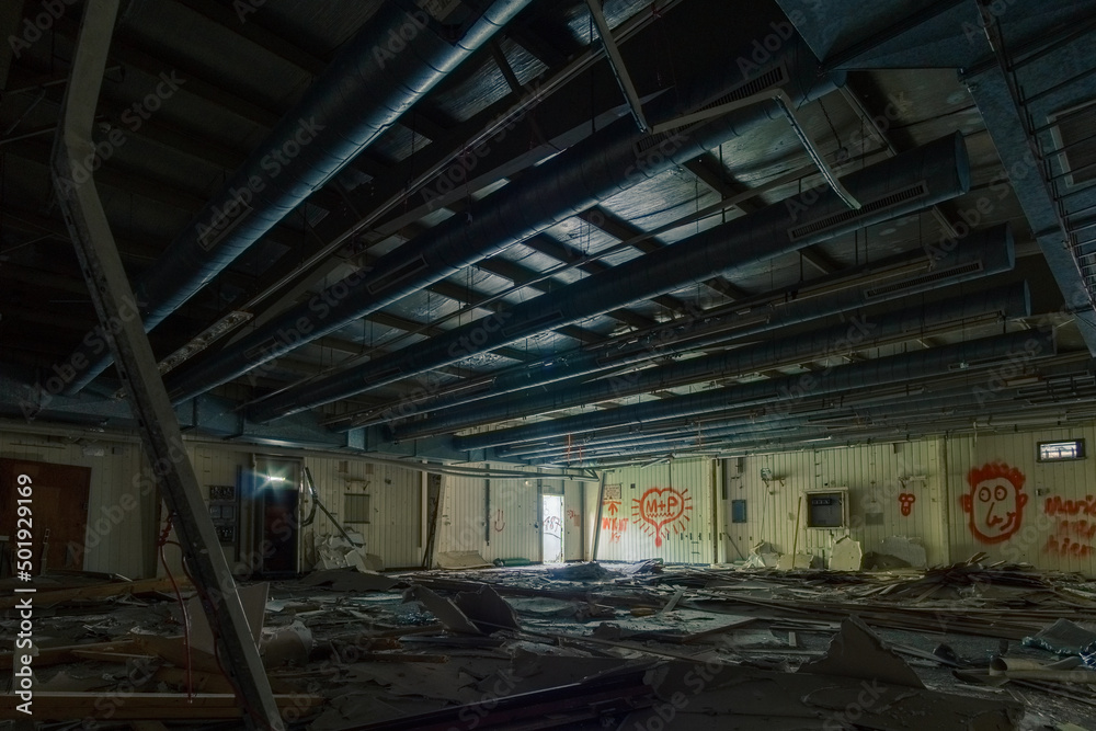inside an old industrial military base hall with broken electric switch cabinets and pipes at the ceiling inside an old industrial military base hall with broken electric switch cabinets and pipes at the ceiling