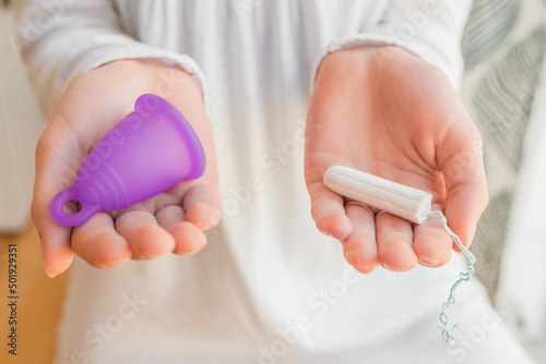 hands of young girl with tampon and menstrual cup  using cup during period. Eco  zero waste
