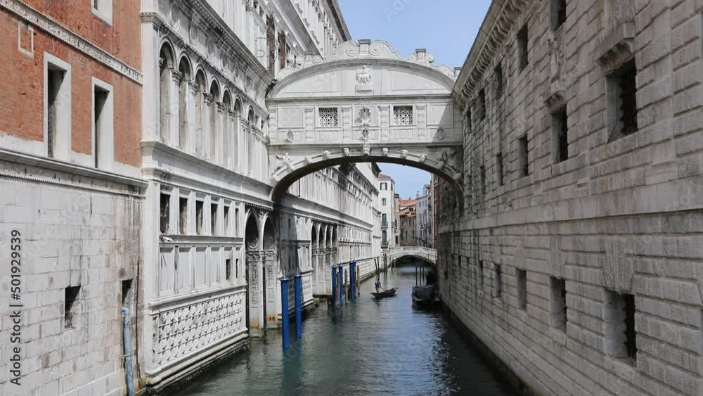 Famous Bridge of Sighs in Venice in Italy called Ponte dei Sospiri in Italian Language with a boat sailing in the navigable canal Famous Bridge of Sighs in Venice in Italy called Ponte dei Sospiri in Italian Language with a boat sailing in the navigable canal