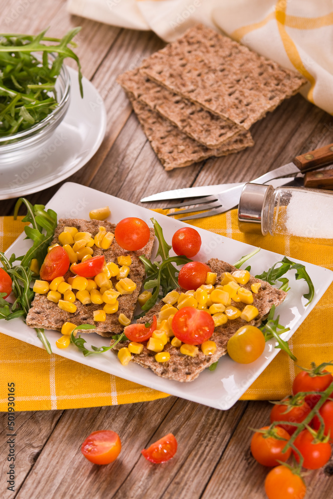 Crispy rye bread with sesame seeds, arugula and sweet corn. Crispy rye bread with sesame seeds, arugula and sweet corn.