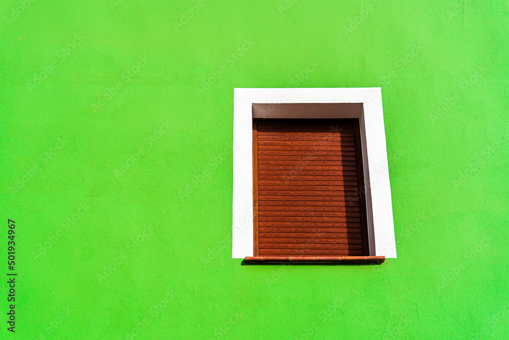 Green wall with brown wooden window.