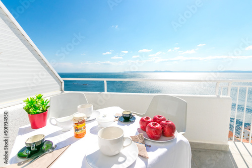 breakfast table on a white terrace with beautiful views of the sea to enjoy your vacation.