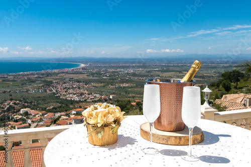 Viewpoint over the Gulf of Roses from the mountain with two glasses and champagne in Spain, Mediterranean Sea, Costa Brava, Alt Empordà, Girona, Catalonia