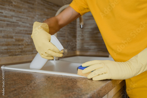 man using spray and sponge for cleaning.