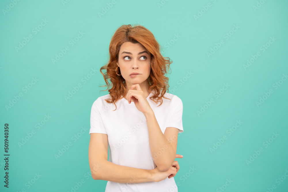 thinking redhead woman with curly hair on blue background thinking redhead woman with curly hair on blue background