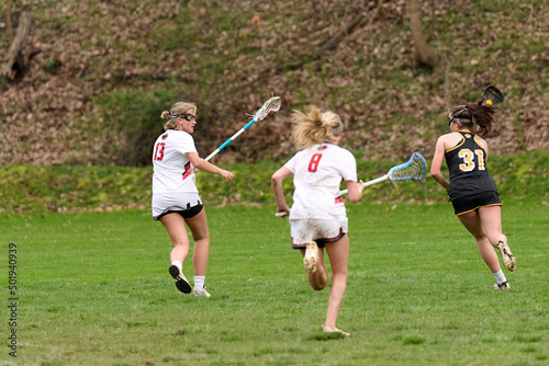 SEWICKLEY, PA, USA - APRIL 21ST 2022: Teenage girls from Sewickley Academy play senior school varsity lacrosse game against North Allegheny High School. Lots of goals and action on this rainy day.
