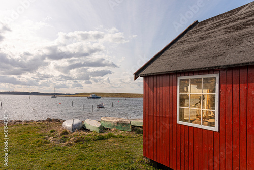 a red hut on the shore an some boats at Jyllinge, Denmark, Marts 29, 2022 photo